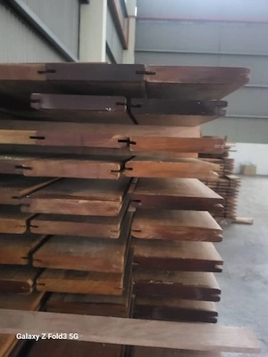 Stack of moulded wooden planks with tongue and groove joints in a warehouse setting